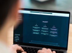 A man is looking at the screen of an open laptop computer